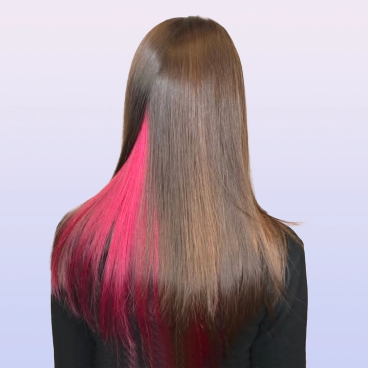 A picture of hair partially colored with red highlights, adding vibrant accents to dark hair