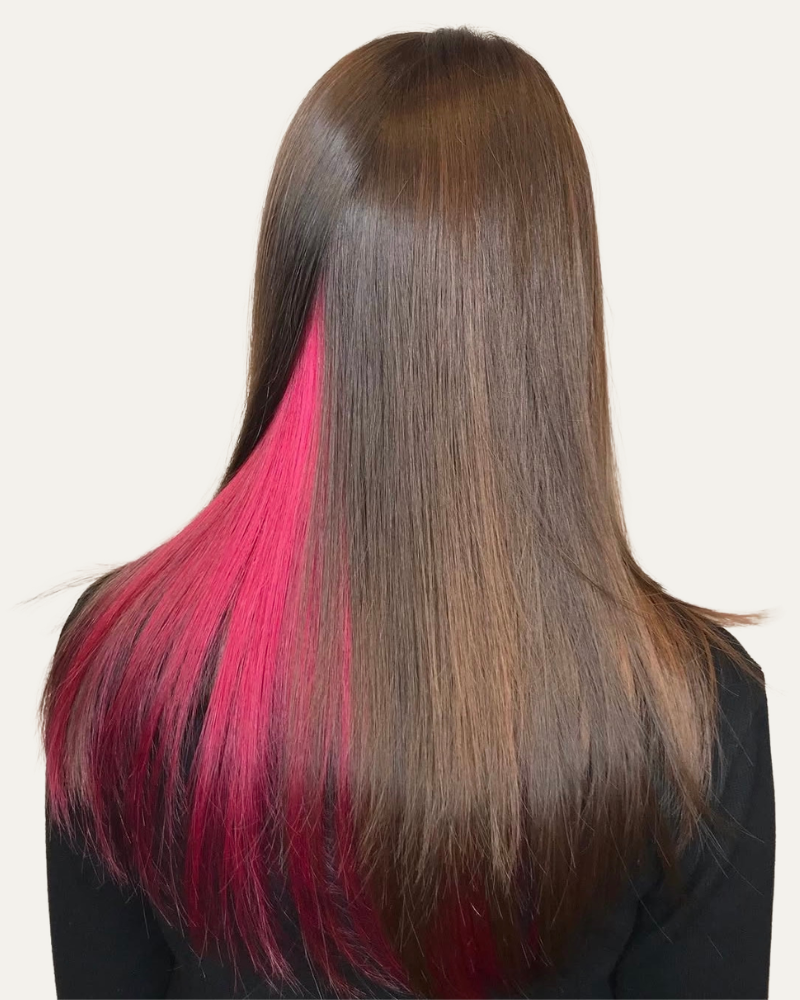 A picture of hair partially colored with red highlights, adding vibrant accents to dark hair